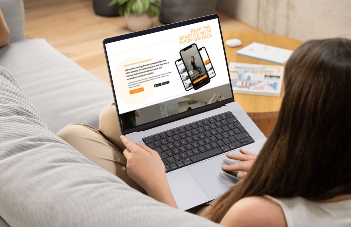 woman scrolling on laptop at fitness studio website